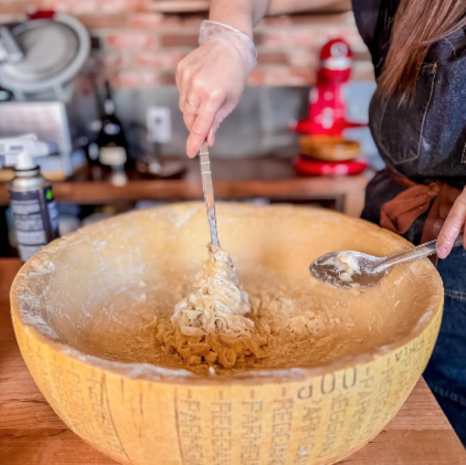 Pasta tossed by hand inside a hollowed Parmigiano-Reggiano wheel